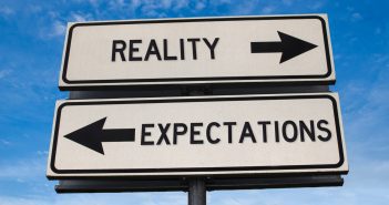 Picture of road signs pointing opposite ways saying Reality and Expectations