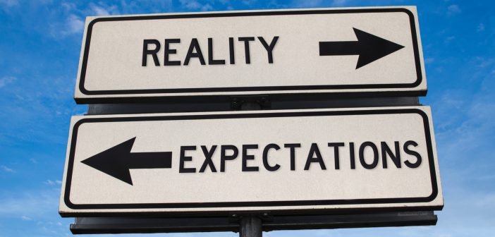 Picture of road signs pointing opposite ways saying Reality and Expectations