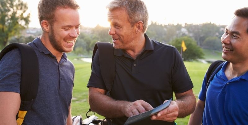 Golfers discussing scoring per the golf tournament format.
