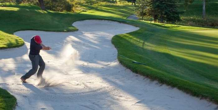 Golfer hitting a shot out of a bunker